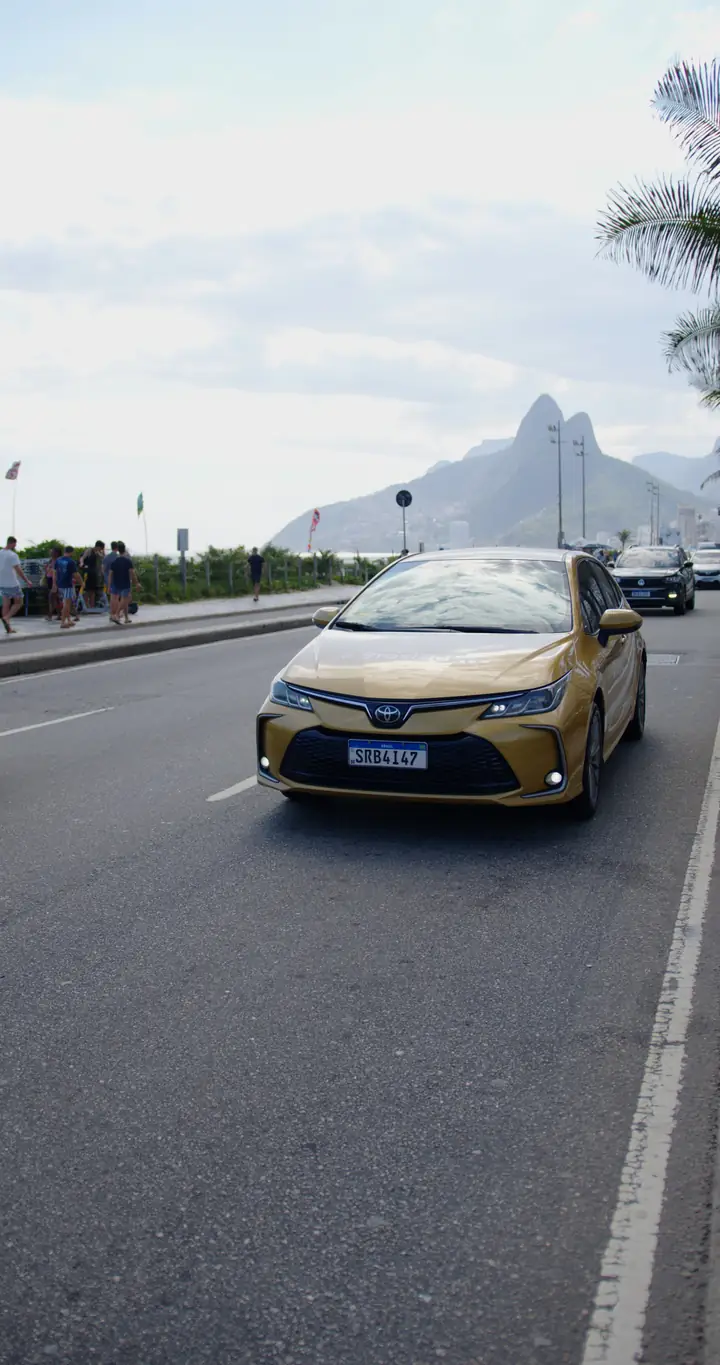 Carro executivo Braslectra na orla do Rio de Janeiro, com o Morro Dois Irmãos ao fundo