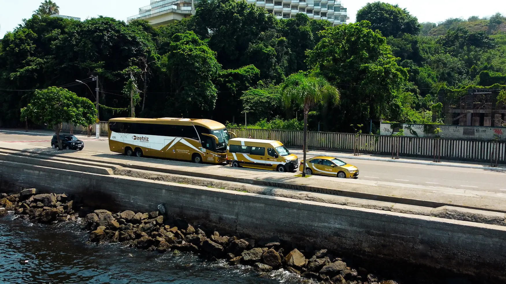 Frota do Grupo Braslectra — ônibus, van e carro executivo na orla